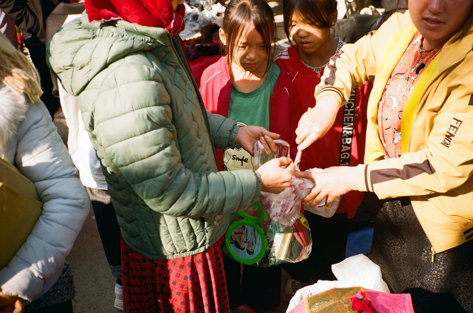 Crowd of people in winter jackets gathered close, hands meeting in the middle